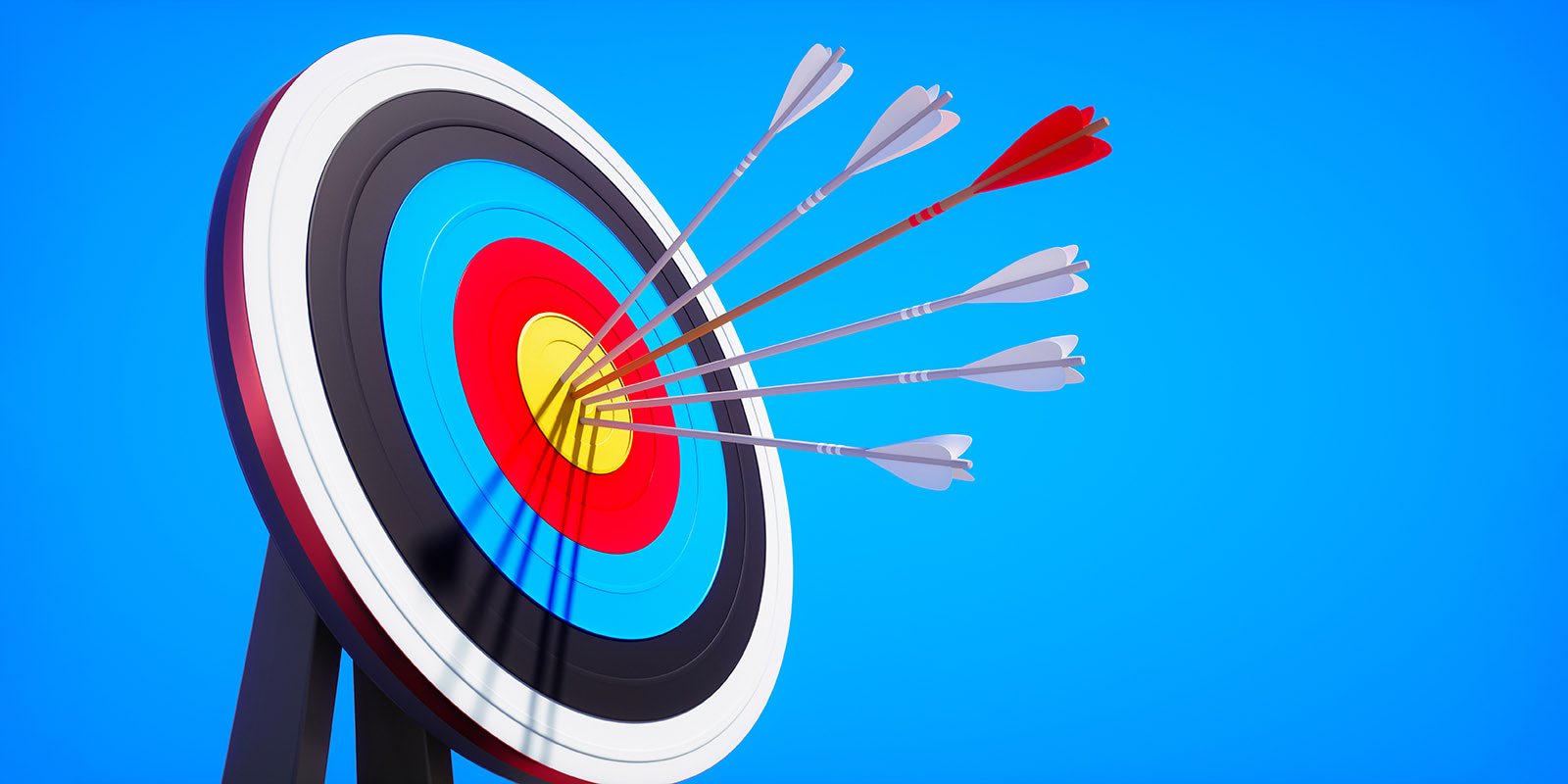 A group of arrows strike the center of a target.